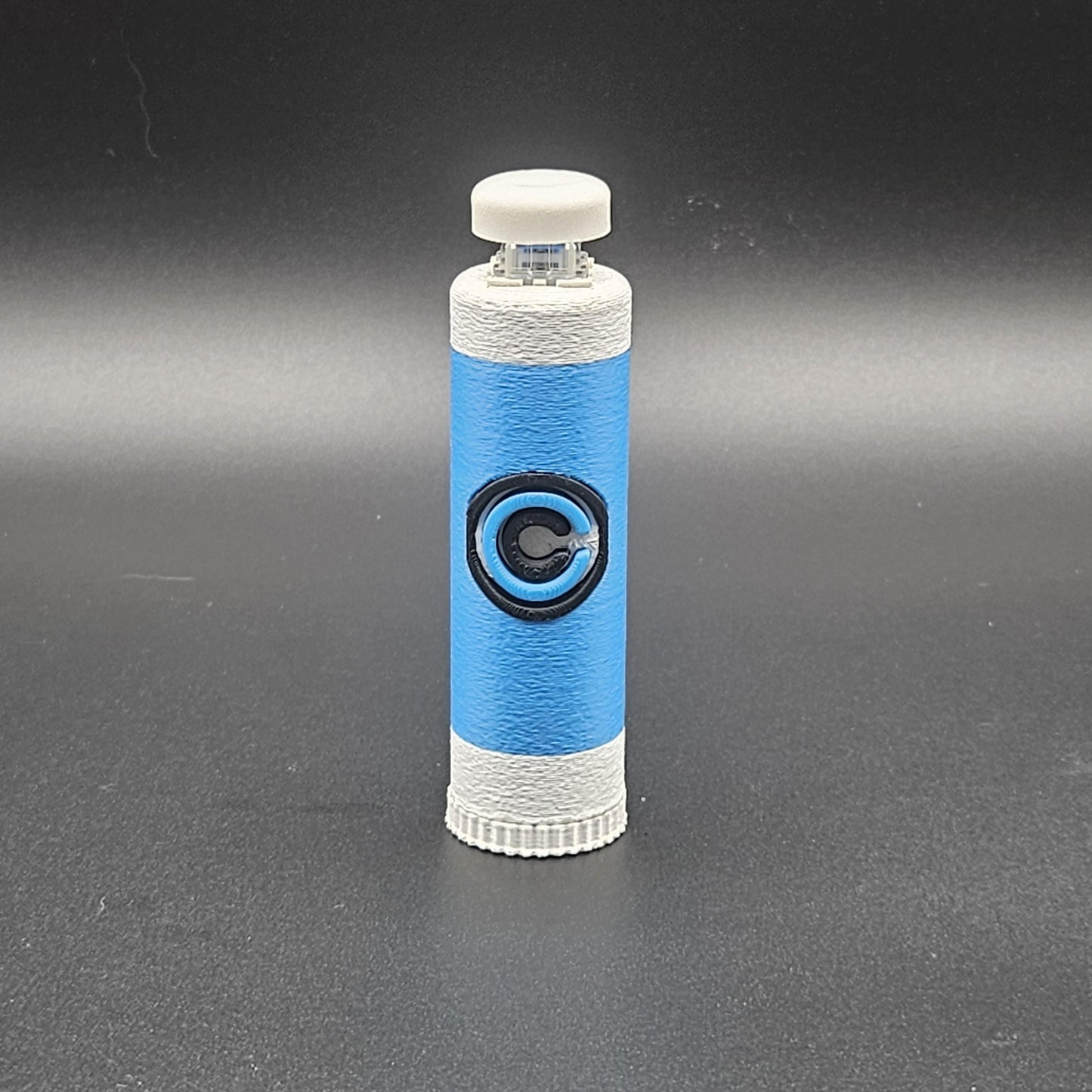 Blue and white clicky fidget with storage compartment DBZ featuring a circular emblem on a black background
