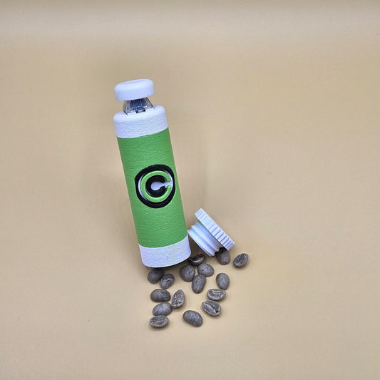 Green and white clicky fidget with storage compartment DBZ and scattered small items on beige background