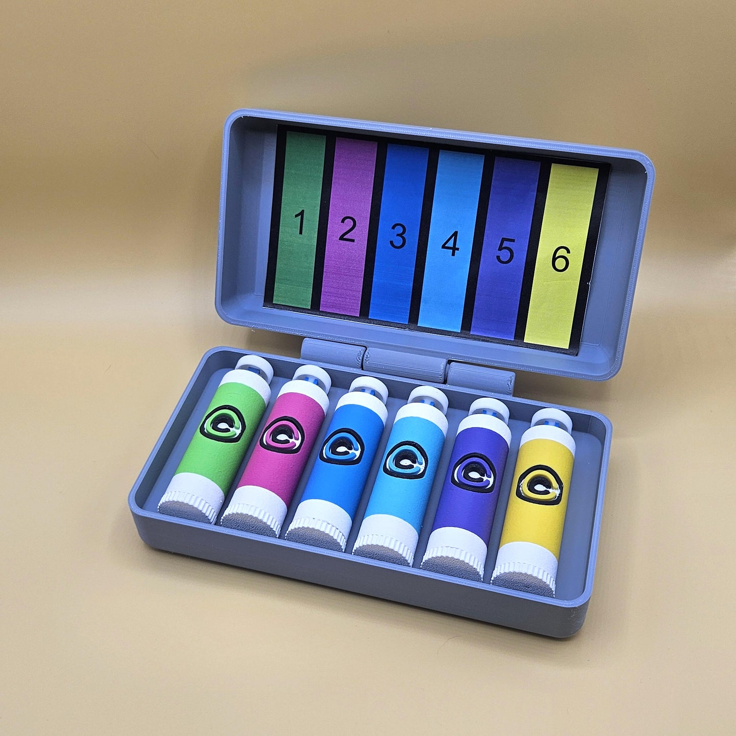 clicky fidget with storage compartment DBZ in gray case with six colorful clicky tubes and numbered cards